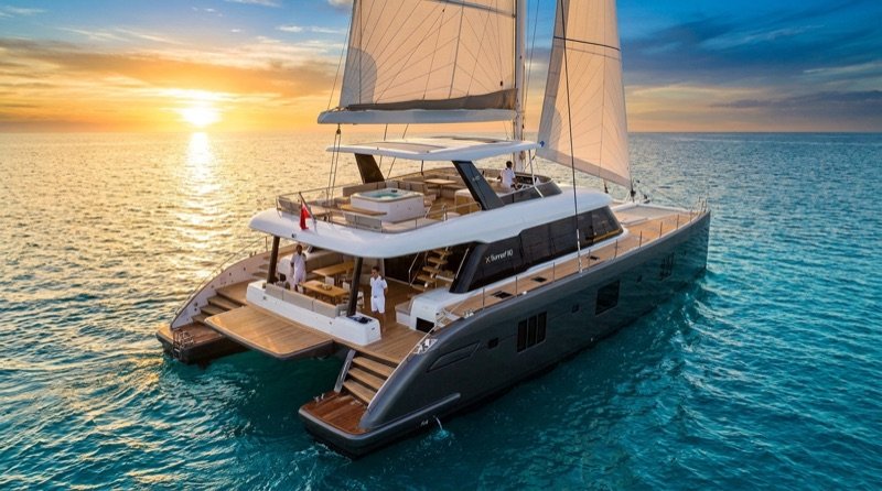Large sailing catamaran underway at sunset
